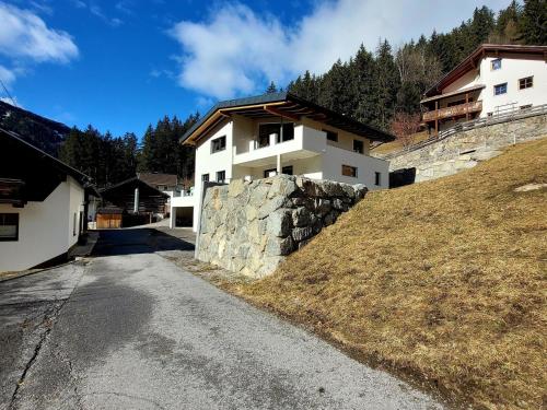 a house on a hill with a stone wall at Apartment in Pitztal near Ski Glacier in Oberlehn