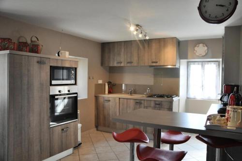 une cuisine avec des armoires en bois et une table et des chaises dans l'établissement Gîte de France Gîte de la barbacane 3 épis - Gîte de France 5 personnes MAE-8884, à Curemonte