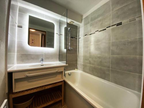 une salle de bain avec un lavabo, une baignoire et un miroir dans l'établissement Résidence Silveralp - Val Thorens location: Duplex rénové en dernier étage, proche garderie et école de ski MAE-9064, à Val Thorens