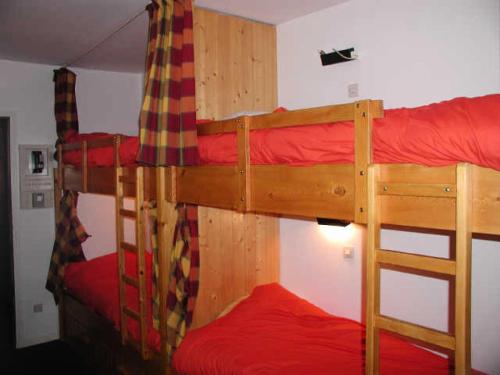 sypialnia z 2 łóżkami piętrowymi i czerwoną pościelą w obiekcie Résidence CHRISTIANIA - Studio pour 6 Personnes 964 w mieście Gourette
