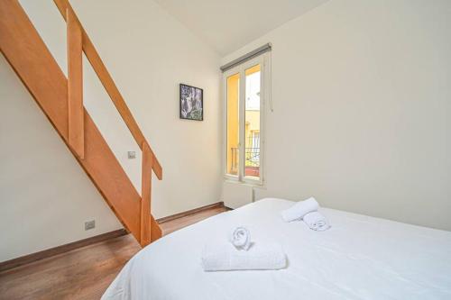 - une chambre blanche avec un lit et un escalier dans l'établissement 