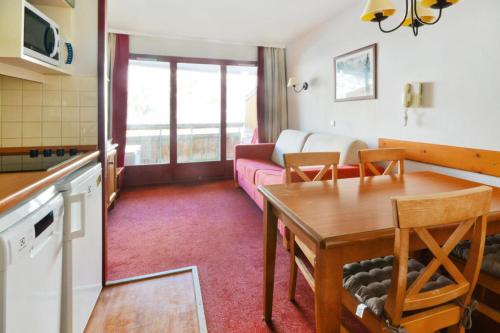 Il dispose d'une cuisine et d'un salon avec un canapé et une table. dans l'établissement Résidence Les Terrasses d'Azur - maeva Home - 2 Pièces 4 Personnes Confort MAE-1522, à Isola 2000