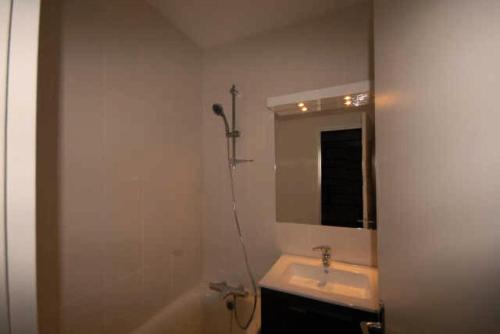 une salle de bain avec un lavabo, une baignoire et un miroir dans l'établissement Résidence SANCTUS - Studio pour 6 Personnes MAE-9054, à Gourette