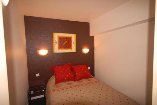 - une petite chambre avec un lit et des oreillers rouges dans l'établissement Résidence MARMOTTES - Studio pour 8 Personnes MAE-9014, à Gourette