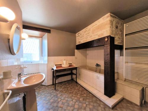 une salle de bain avec un lavabo et une baignoire dans l'établissement Gîte de France Le pouget 3 épis - Gîte de France 7 personnes MAE-8944, à Albussac
