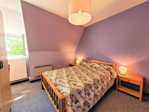 - une chambre avec un lit et un mur violet dans l'établissement Gîte de France Le pouget 3 épis - Gîte de France 7 personnes MAE-8944, à Albussac
