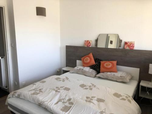 - une chambre avec un lit doté d'oreillers orange et d'un miroir dans l'établissement Résidence PENE MEDAA - 2 Pièces pour 6 Personnes MAE-9024, à Gourette