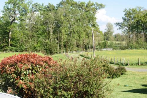a garden with a fence and a field at Gîte de France à Saint-Bonnet-la-Rivière 3 épis - Gîte de France 8 personnes MAE-8984 in Laval