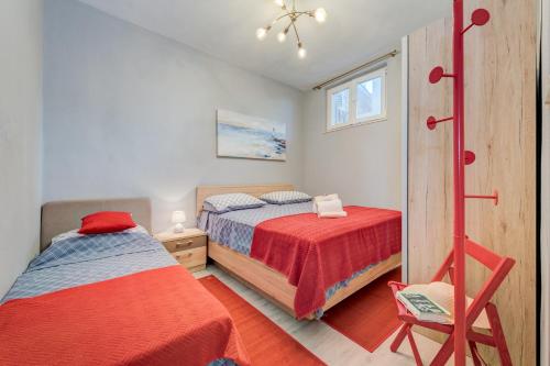 ein Schlafzimmer mit 2 Betten und einem Stuhl darin in der Unterkunft Blue Paradise Apartman 2 in Sevid