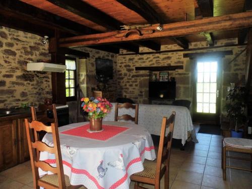 - une salle à manger avec une table et des fleurs dans l'établissement Gîte de France Chez le garde 3 épis - Gîte de France 4 personnes MAE-8974, à Lanteuil