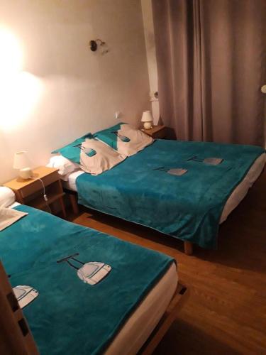 2 camas en una habitación de hotel con sábanas verdes en Appartement 3 pièces 7 pers avec vue magnifique sur les Pyrénées 79268, en Font-Romeu-Odeillo-Via