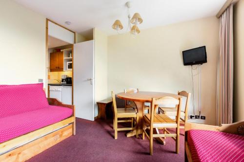 Cette chambre comprend une table, un lit et une cuisine. dans l'établissement Quartier Crève Cœur - maeva Home - Appartement 2 pièces 4 personnes - Confort MAE-4002, à Valmorel