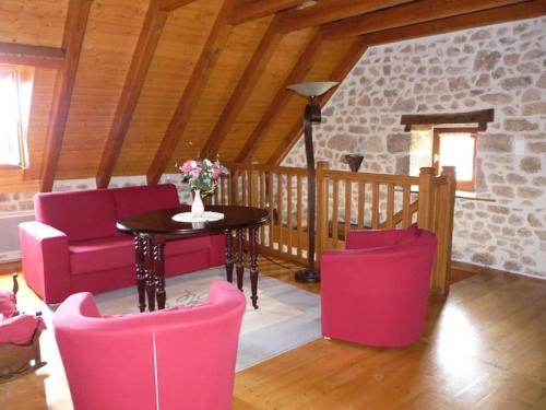 a living room with pink chairs and a table at Gîte de France La closerie de la coussière 3 épis - Gîte de France 5 per 054 