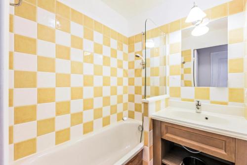 une salle de bain avec une baignoire et un lavabo et une baignoire dans l'établissement Résidence L'Albane - maeva Home - Appartement 2 pièces 6 personnes Selection MAE-4508, à Vars