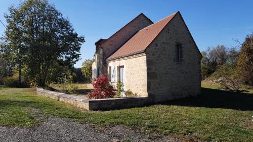 an old brick church with a flower bed in front of it at Gîte de France Gîte de duroux 3 épis - Gîte de France 6 personnes MAE-9134 in Estivals