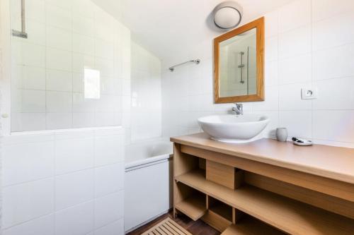 une salle de bain blanche avec un lavabo et un miroir dans l'établissement Résidence Plagne Lauze - maeva Home - Appartement 4 pièces 8 personnes Selection MAE-4893, à Mâcot La Plagne