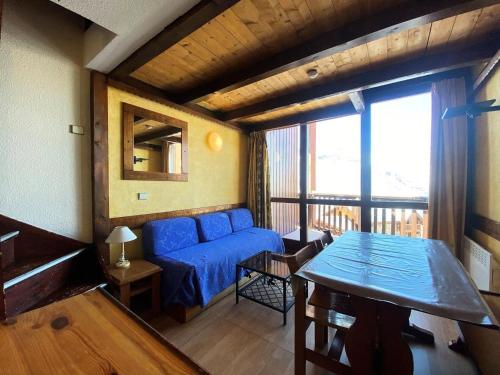 un salon avec un canapé bleu et une table dans l'établissement Résidence Silveralp - VAL THORENS location: Proche garderie et école de ski, appartement 4 pers avec mezzanine MAE-9083, à Val Thorens