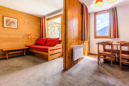 une chambre avec un canapé rouge, une table et une salle à manger dans l'établissement Quartier Crève Cœur - maeva Home - Studio 4 personnes Selection MAE-5129, à Valmorel