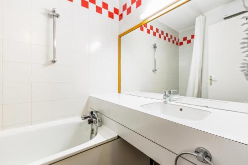 une salle de bain avec un lavabo, une baignoire et un miroir dans l'établissement Quartier Crève Cœur - maeva Home - Studio 4 personnes Selection MAE-5129, à Valmorel