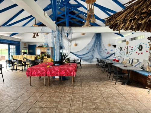 Vaitoare的住宿－Pension Hibiscus Taha'a，一间用餐室,配有红色的桌子和椅子