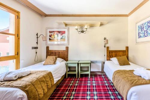 Cette chambre comprend 2 lits et une table verte. dans l'établissement Résidence Les Arcs 1950 Le Village - maeva Home - 2 pièces 4 pers Sélection MAE-5872, à Bourg-Saint-Maurice