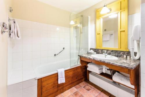 une salle de bain avec une baignoire, un lavabo et une douche dans l'établissement Résidence Les Arcs 1950 Le Village - maeva Home - 2 pièces 4 pers Sélection MAE-5872, à Bourg-Saint-Maurice