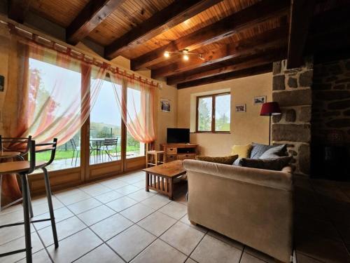 a living room with a couch and a large window at Gîte de France à Meymac 3 épis - Gîte de France 4 personnes MAE-9204 in Meymac