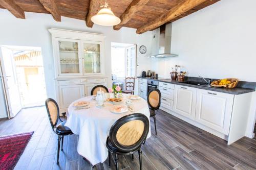 une cuisine avec une table et des chaises dans une pièce dans l'établissement Gîte de France Le clos du bournazel 4 épis - Gîte de France 4 personnes MAE-9254, à Albignac