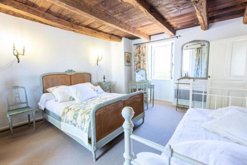 a bedroom with two beds and a wooden ceiling at Gîte de France Le clos du bournazel 4 épis - Gîte de France 4 personnes 254 in Albignac