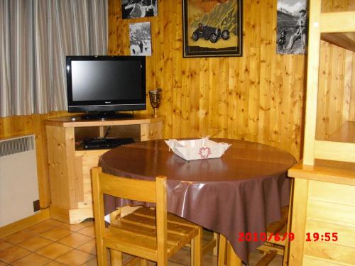 a dining room with a table and a television at Studio 5 personnes avec vue montagne 82171 in Lanslevillard