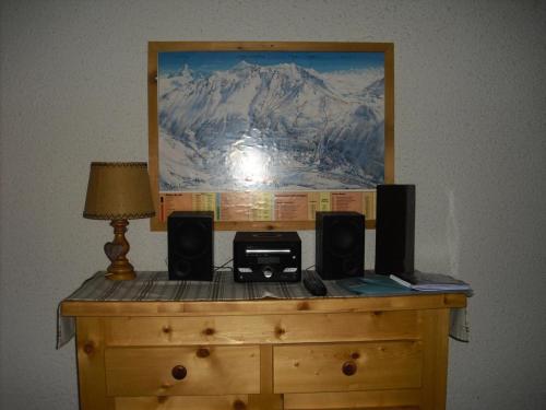 a wooden dresser with speakers and a picture on it at Studio 5 personnes avec vue montagne 82171 in Lanslevillard