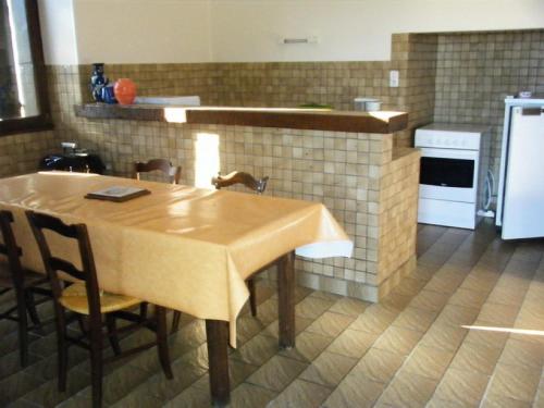 une cuisine avec une table, des chaises et un réfrigérateur dans l'établissement Gîte de France à Juillac ( correze) 2 épis - Gîte de France 5 personnes MAE-9274, à Juillac