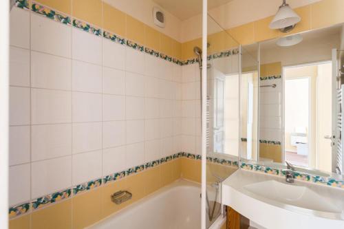 une salle de bain avec une baignoire, un lavabo et un miroir dans l'établissement Résidence Le Thabor - maeva Home - 2 Pièces 5 Personnes Confort MAE-7571, à Le Désert