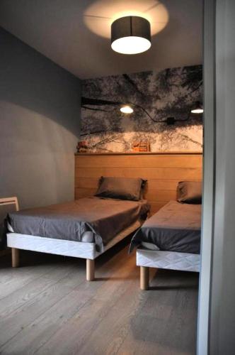 une chambre avec deux lits et un tableau au mur dans l'établissement Gîte de France Gîte de chaviolle 4 épis - Gîte de France 6 personnes MAE-9284, à Bassignac-le-Bas