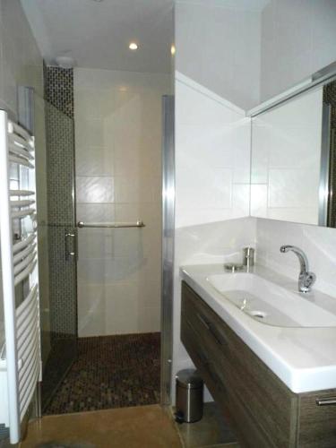 une salle de bain blanche avec un lavabo et une douche dans l'établissement Gîte de France Gîte de chaviolle 4 épis - Gîte de France 6 personnes MAE-9284, à Bassignac-le-Bas