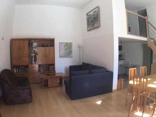 un salon avec un canapé bleu et une table dans l'établissement Appartement 4 pièces 10 pers. en plein centre de la station - 4 Pièces 10 personnes MAE-7675, à Termignon