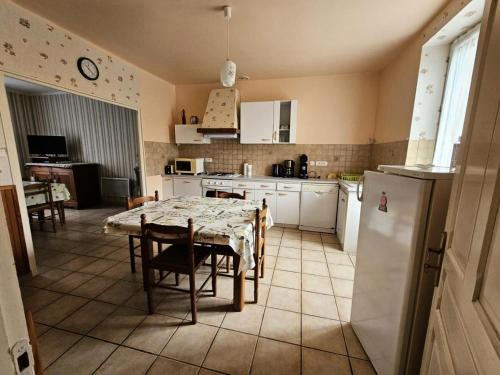 a kitchen with a table and a kitchen with a refrigerator at Gîte de France à Bar (Correze) 3 épis - Gîte de France 5 personnes 314 in Bar