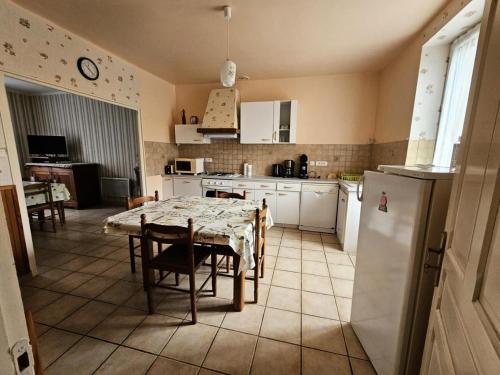 a kitchen with a table and a kitchen with a refrigerator at Gîte de France à Bar (Correze) 3 épis - Gîte de France 5 personnes MAE-9314 in Bar