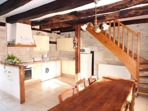 une cuisine avec une table en bois et un escalier dans l'établissement Gîte de France à Turenne 3 épis - Gîte de France 6 personnes MAE-9334, à Turenne