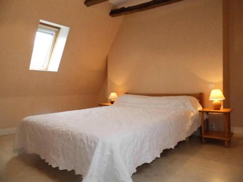 een slaapkamer met een wit bed en een raam bij Gîte de France à Turenne 3 épis - Gîte de France 6 personnes 334 in Turenne