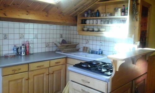 une cuisine avec une cuisinière et un évier dans l'établissement Appartement 3 pièces 5 personnes chaleureux avec vue montagne - 3 Pièces 5 personnes MAE-7735, à Aussois