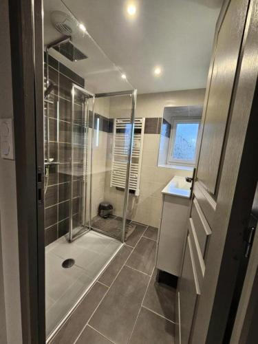 une salle de bain avec une douche avec une porte vitrée dans l'établissement Gîte de France Chez jeannette 3 épis - Gîte de France 6 personnes MAE-9344, à Albignac