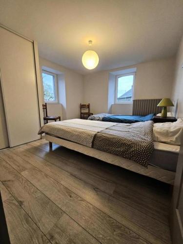 une chambre avec un grand lit et une lampe dans l'établissement Gîte de France Chez jeannette 3 épis - Gîte de France 6 personnes MAE-9344, à Albignac