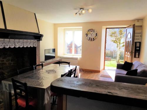 un salon avec une table et une cheminée dans l'établissement Gîte de France à Alleyrat 3 épis - Gîte de France 4 personnes MAE-9324, à Alleyrat