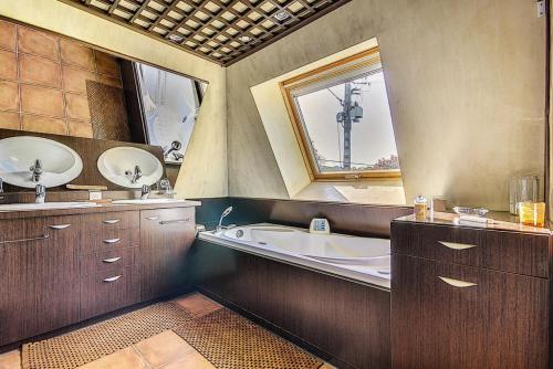 uma casa de banho com uma banheira, um lavatório e um espelho. em Gîte de France Bayat 4 épis - Gîte de France 5 personnes 354 em Varetz