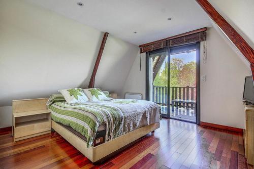 um quarto com uma cama e uma varanda em Gîte de France Bayat 4 épis - Gîte de France 5 personnes 354 em Varetz