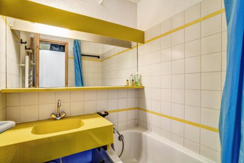 y baño con lavabo amarillo y bañera. en Appartement bien situé aux Coches - maeva Home 83322, en Les Coches