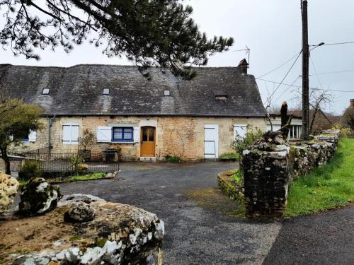 a stone house with a stone fence in front of it at Gîte de France à Chasteaux 2 épis - Gîte de France 4 personnes MAE-9364 in Chasteaux