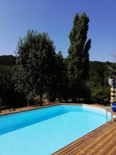 une grande piscine bleue sur une terrasse en bois dans l'établissement Gîte de France La valade 2 épis - Gîte de France 4 personnes MAE-9404, à Cublac