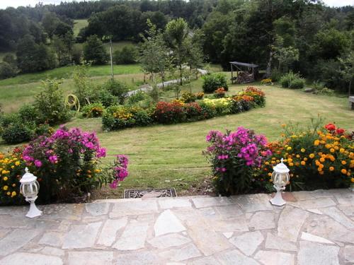 a garden with colorful flowers and a lawn at Gîte de France Chez dédé et léa 3 épis - Gîte de France 6 personnes MAE-9414 in Sarroux